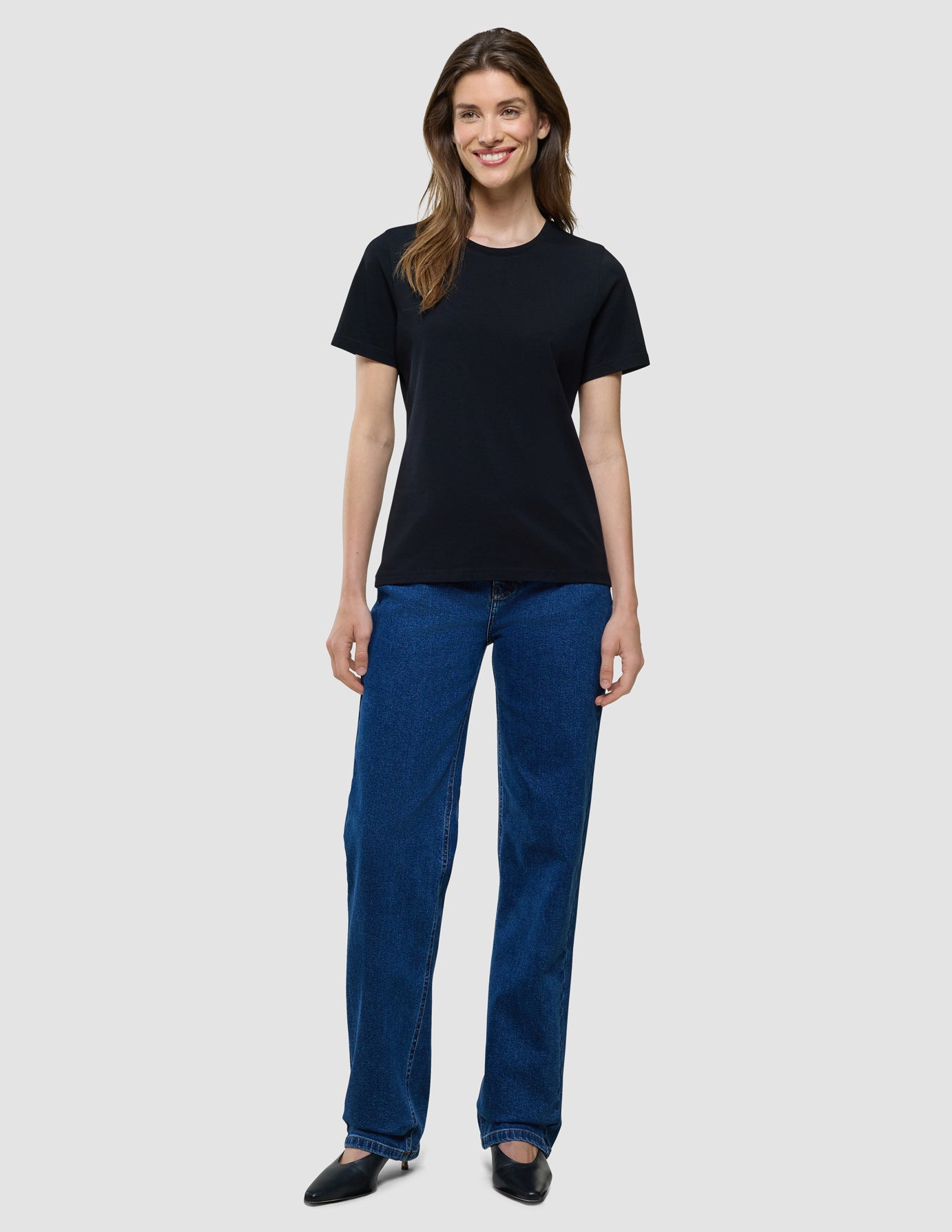 Supima T-Shirt i Black, helfigur på model i sort t-shirt og blå jeans.